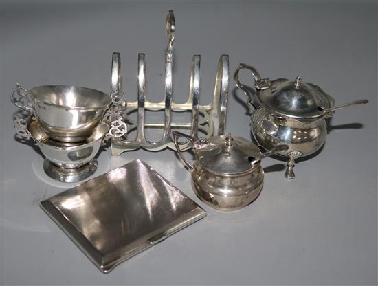 Four silver condiments, a silver toastrack and silver cigarette case.